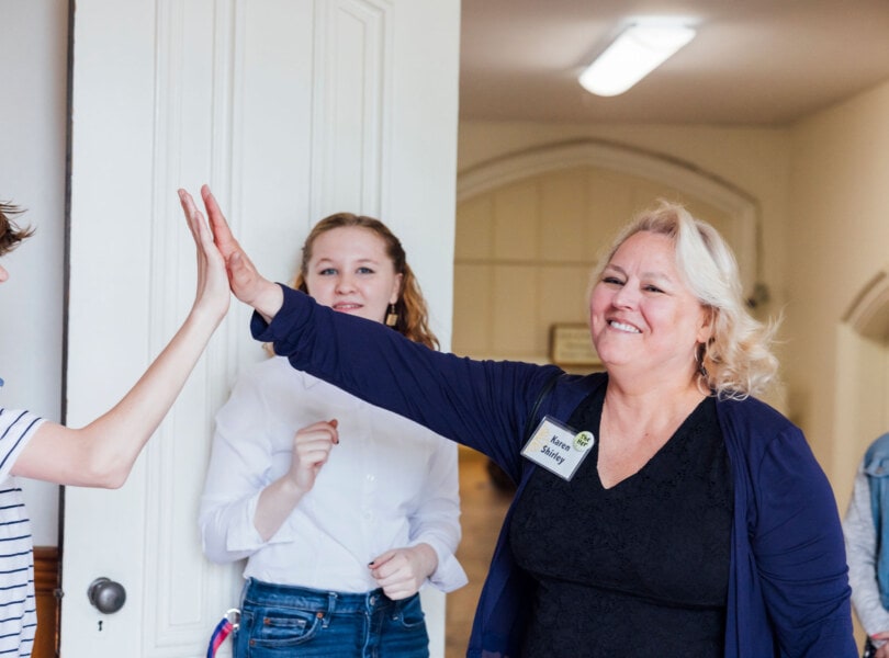 A woman high-fives a teenager