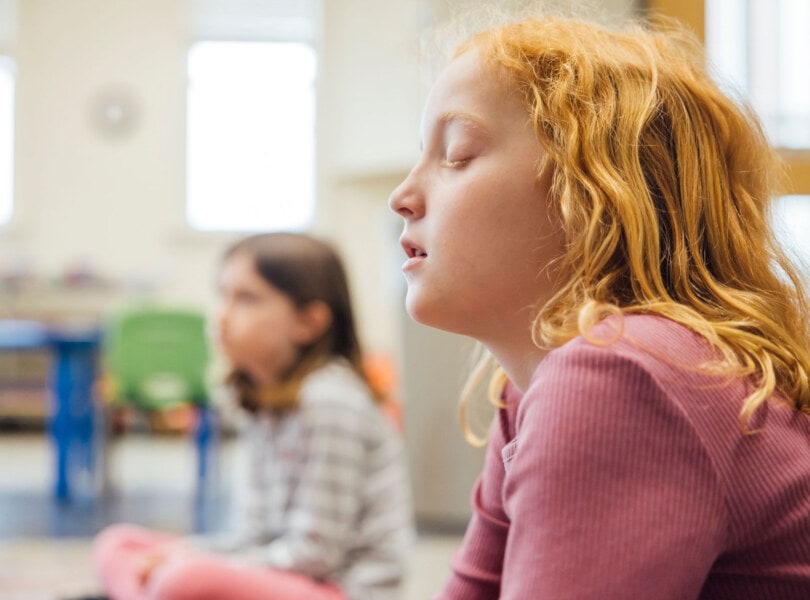 A child closes her eyes in prayer