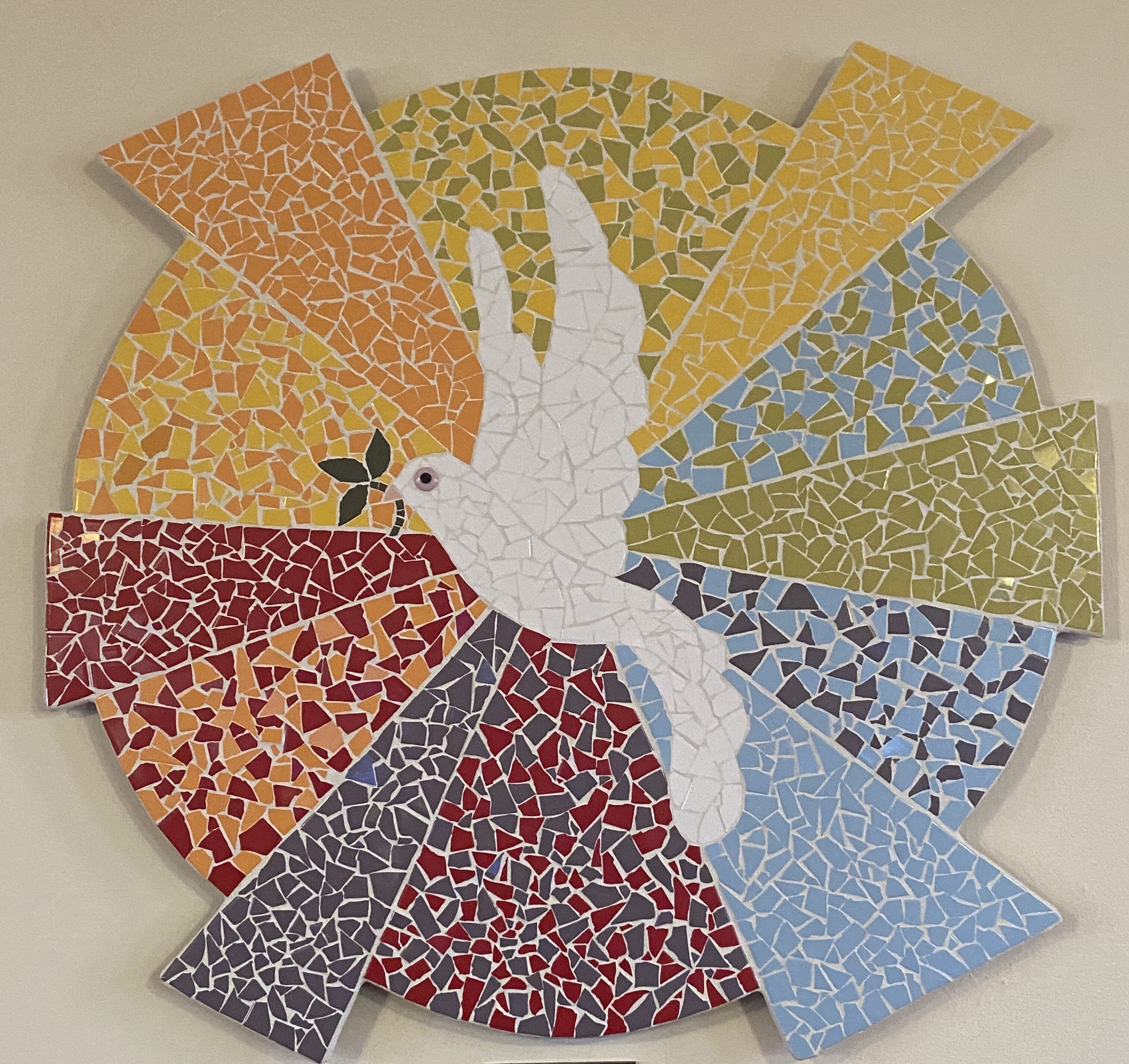 Peace Dove Mosaic Mosiac artwork of a white dove holding an olive branch flying in front of a multicolored sun.