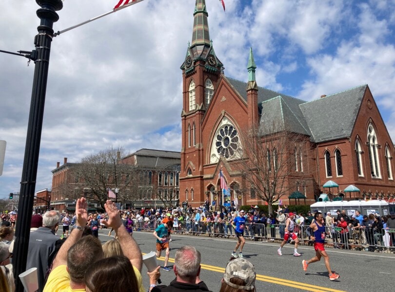 Boston Marathon runners going past the church