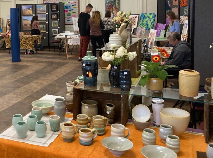 Many tables of artwork by various artists