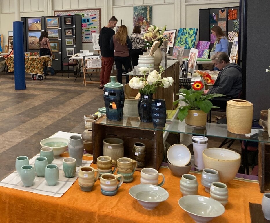 Many tables of artwork by various artists