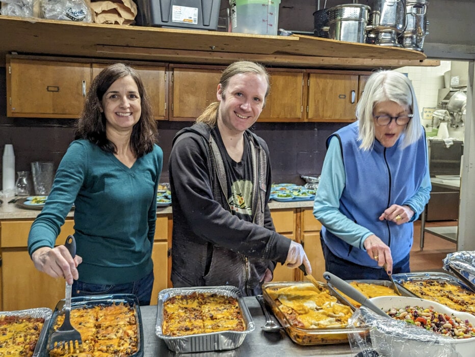 three people serving food