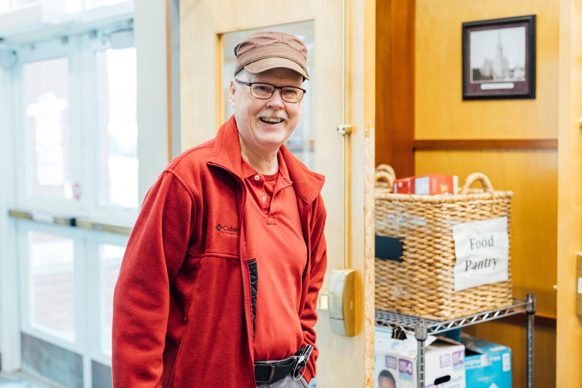 A man in a red shirt and a hat smiling