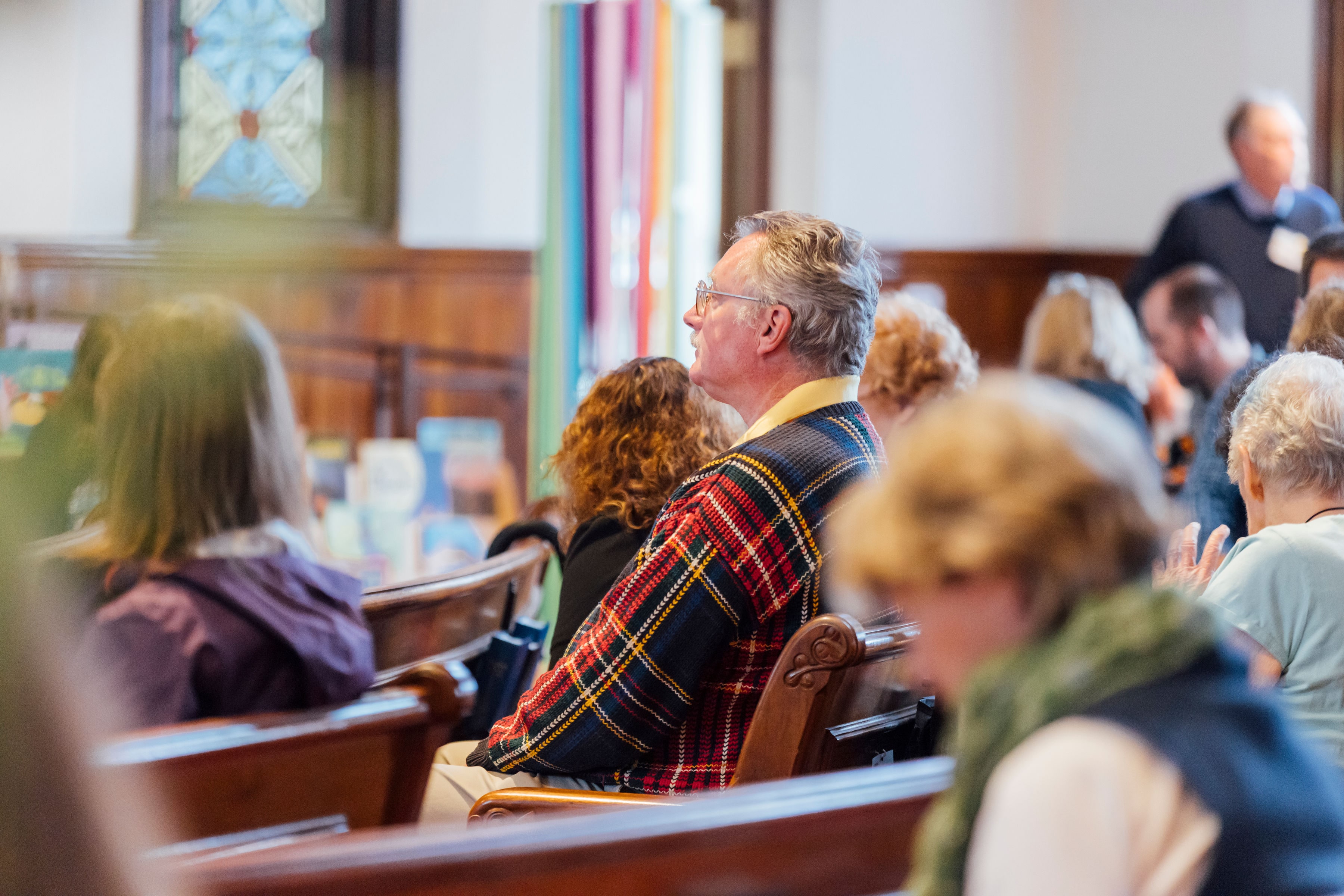 @ bearwalk cinema Man in a church listening during a worship service.