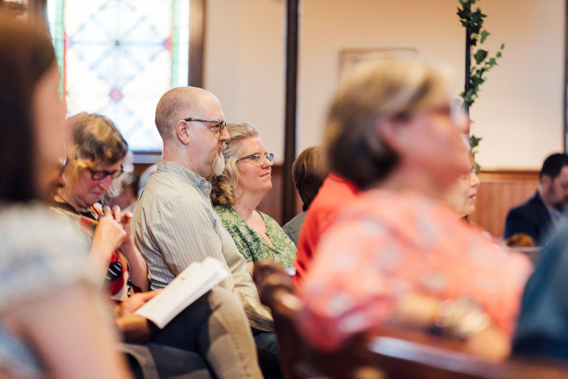 Two congregants listen to a sermon from the pews