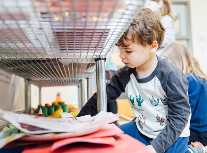 A young boy gathers art supplies