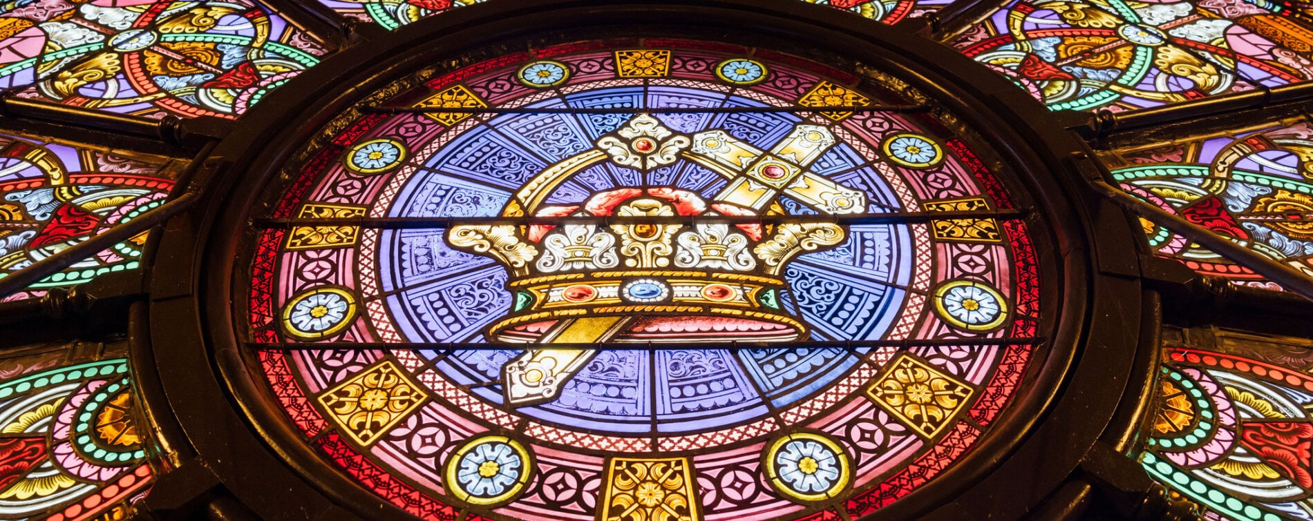 A stained glass window of a crown and sword