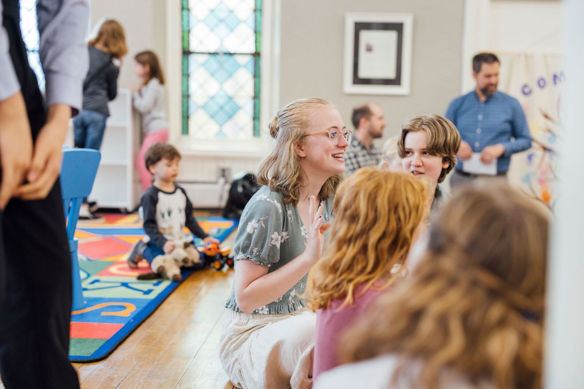 A group of kids of different ages sits in a circle