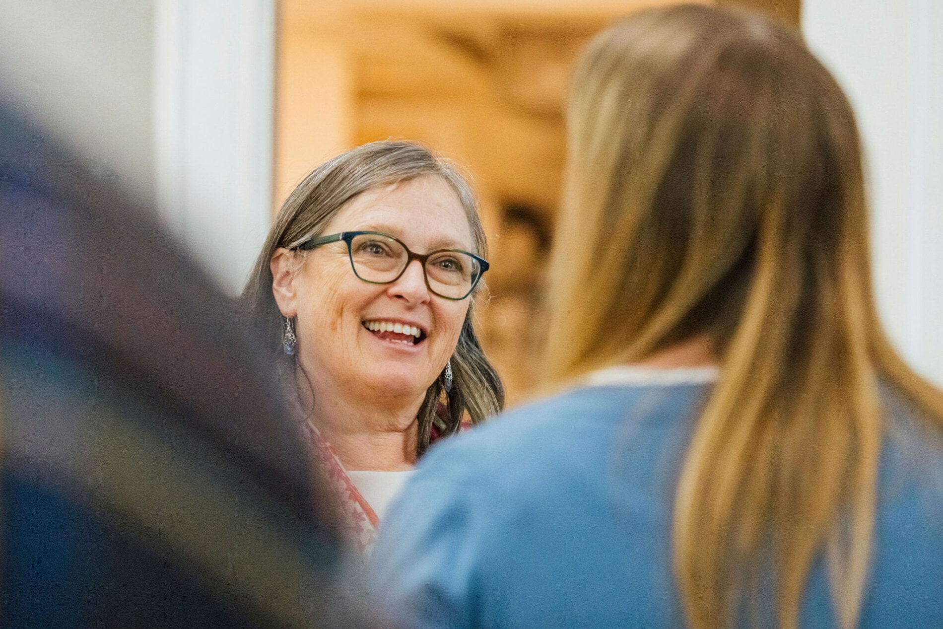 A woman smiling and talking with church members