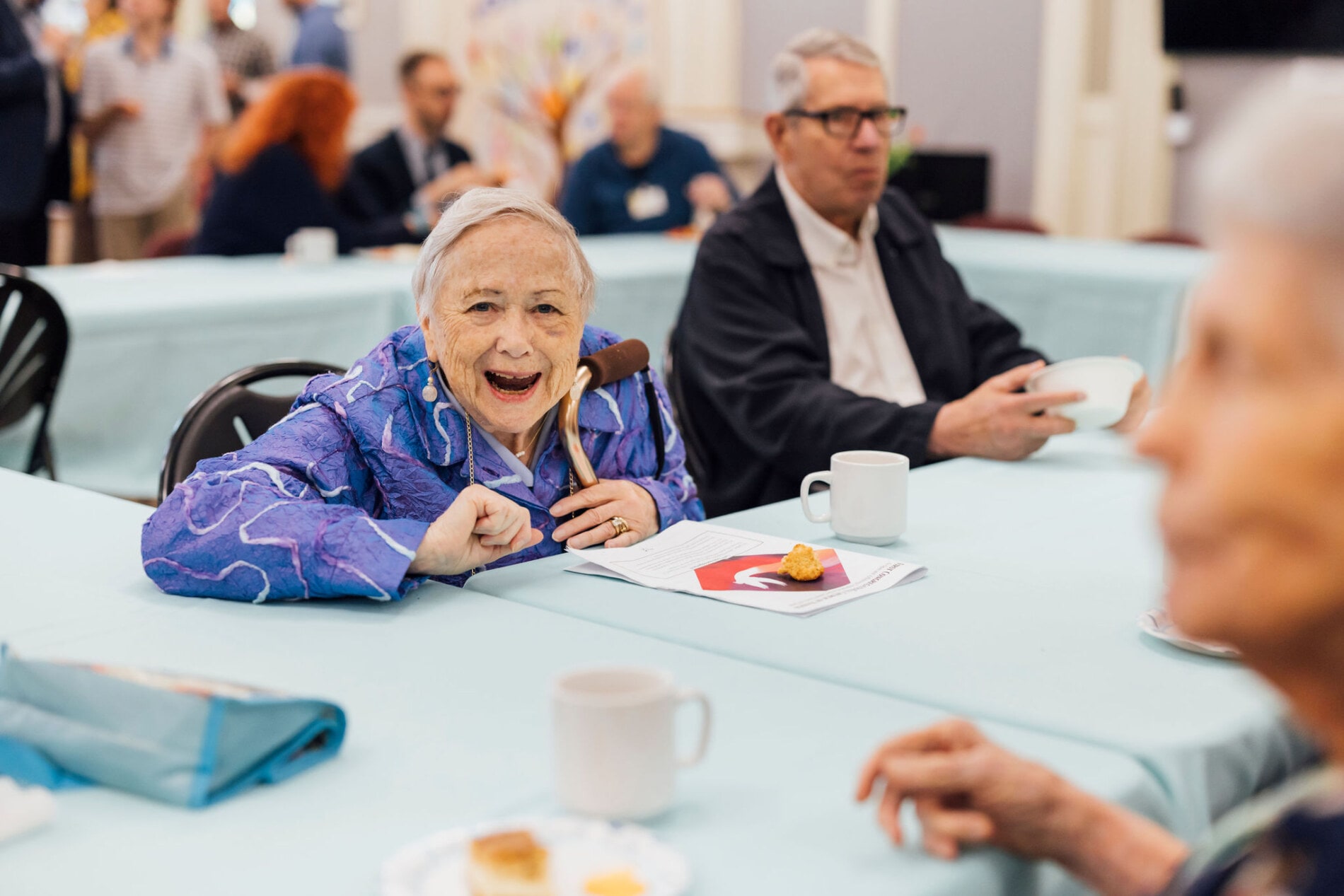 A woman at a table with food laughing