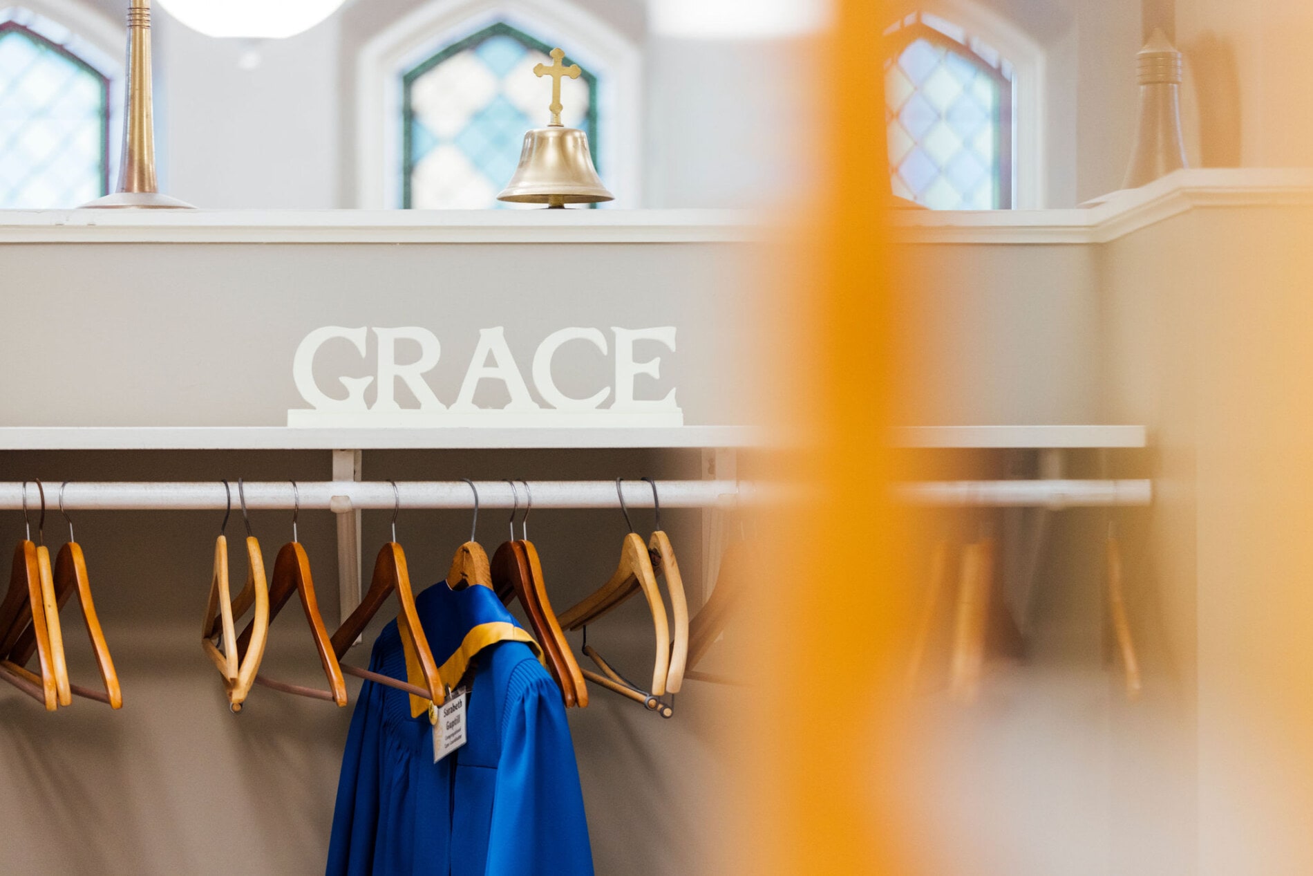 A coat rack with the word "Grace" in carved wood letters above.