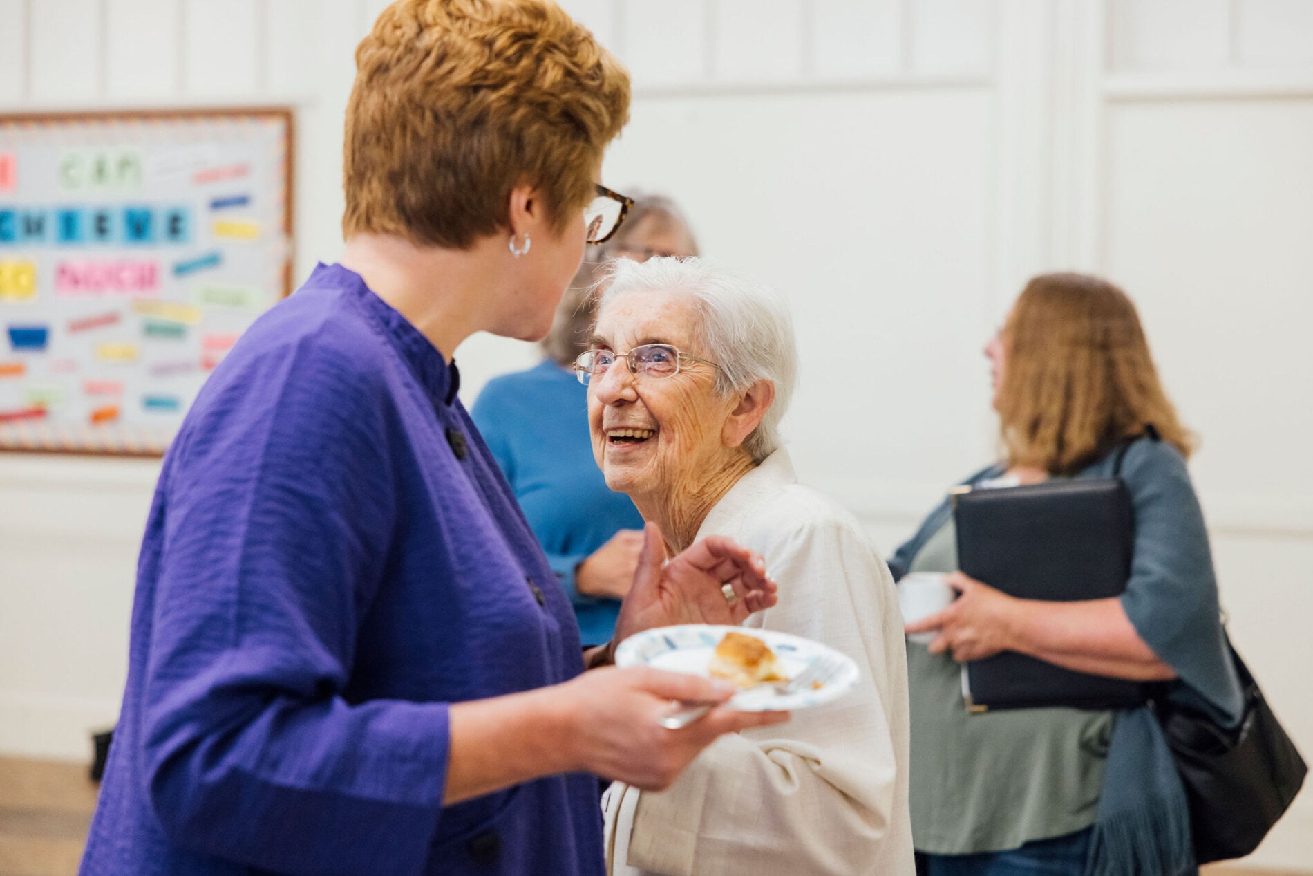 A pastor touches the shoulder of an elderly woman
