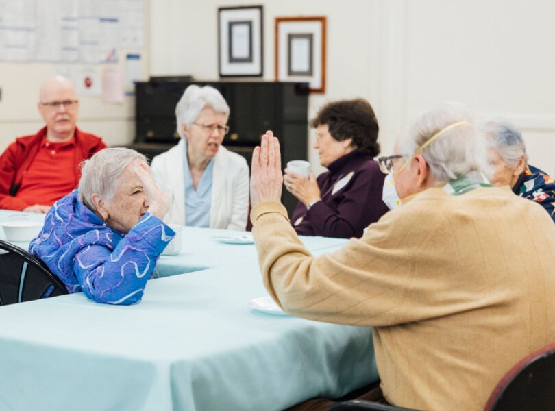 Two people sitting at a table high-fiving