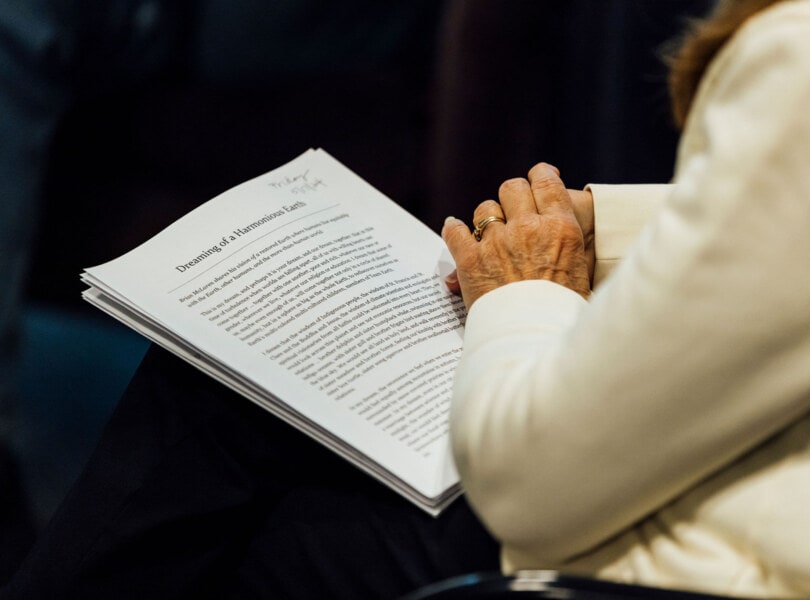 Close up of a persons's hands and a piece of paper with printed text