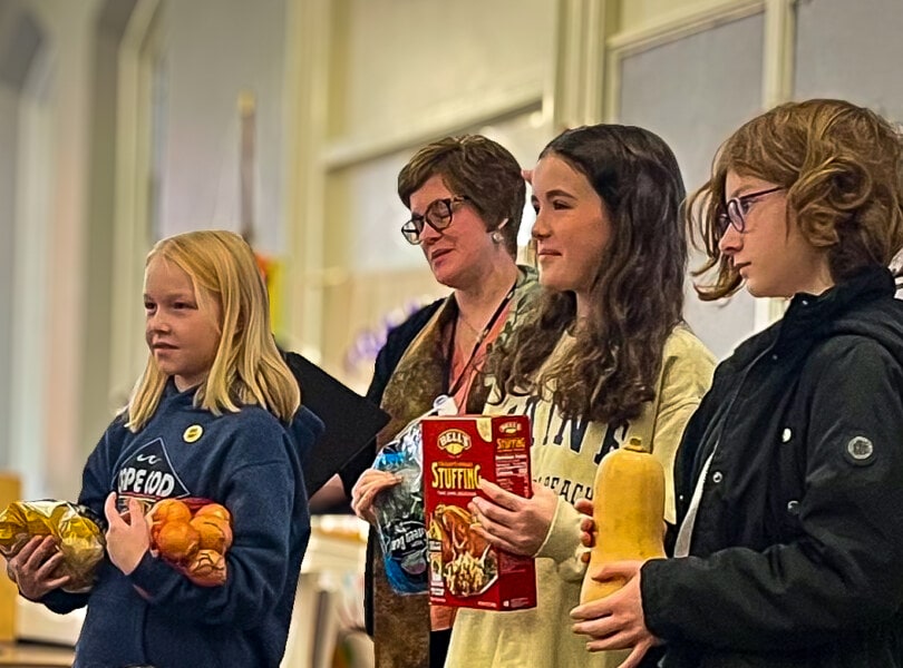 Children holding items collected in a Thanksgiving food drive.