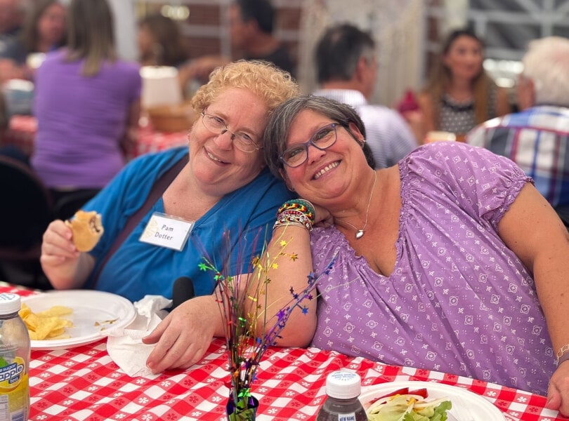 Two women sitting at a picnic table