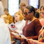 Two women in communal response during worship