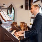 Man playing a pipe organ