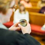 Pastor offering communion wine