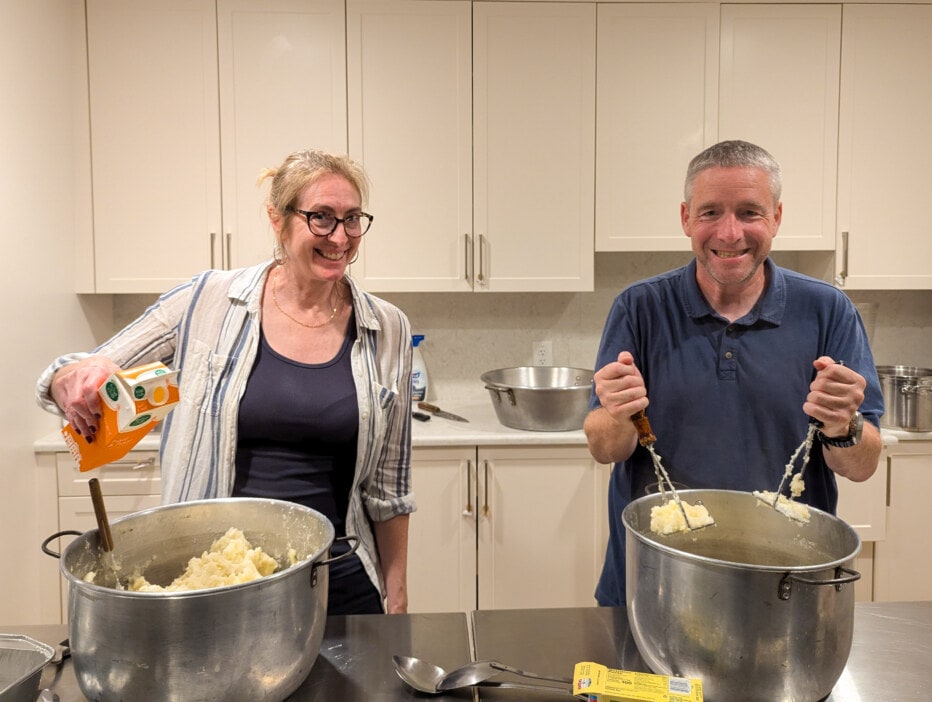 Man and woman mashing 30 pounds of potatoes