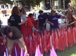 Volunteers plant red flags on church lawn