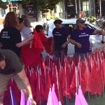Volunteers plant red flags on church lawn