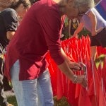 Man hammering red flags into church lawn