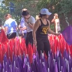Purple and red flags being planted on church lawn