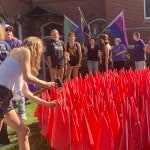 Volunteers setting up red flags on church lawn