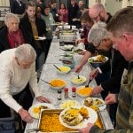 photo of church members in buffet line for food at annual meeting