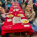 photo of family in vestry at tables for annual meeting enjoying lunch